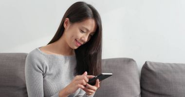 Kadın cep telefonuna bakıyor. 