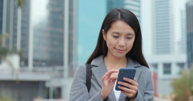 Şehirde Smartphone kullanarak iş kadını 