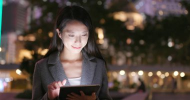 Geceleri tablet bilgisayar kullanarak iş kadını