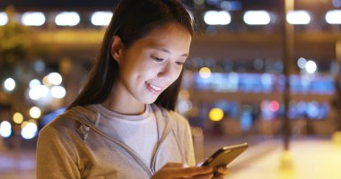 Gece akıllı telefon kullanan bir kadın. 