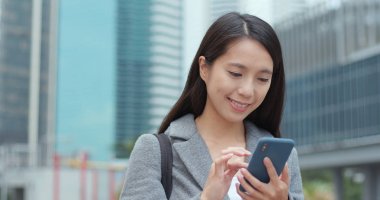 Şehirde akıllı telefon kullanan bir kadın 