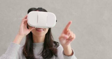 Sanal gerçeklik aygıtıyla izlerken kadın 