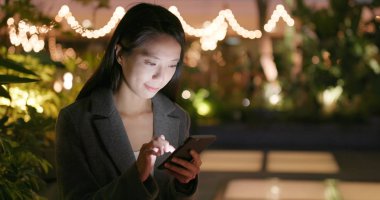 İşkadını Smartphone şehirde geceleri kullanarak. 