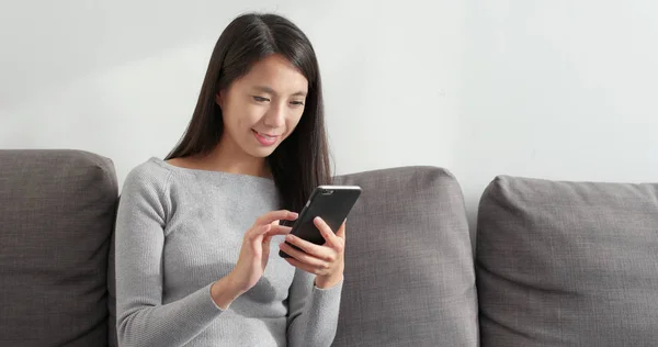 Woman checking on smartphone at home
