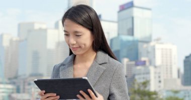 Şehirde tablet bilgisayar kullanarak iş kadını 