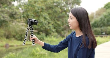 Digital fotoğraf makinesi ile vlog için video çekici kadın 