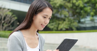 Şehirde tablet bilgisayar kullanarak iş kadını 