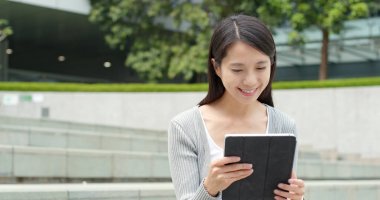 Şehirde tablet bilgisayar kullanan kadın 