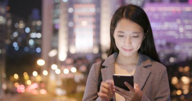 İşkadını Smartphone şehirde geceleri kullanarak.