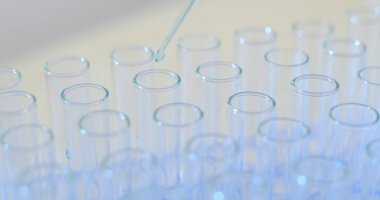 Mavi sıvı test tüpü içinde damla