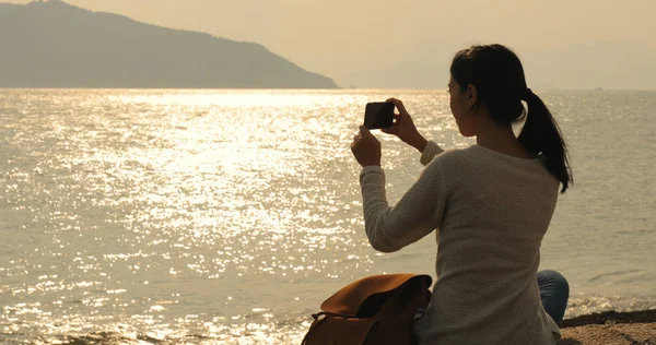 Kobieta Przy Fotografia Morza Pod Zachód Słońca — Zdjęcie stockowe