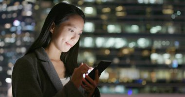 İşkadını Smartphone şehirde geceleri kullanarak. 