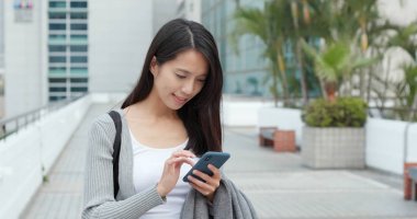 Şehirde Smartphone kullanan genç kadın 