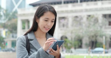 Şehirde akıllı telefon kullanan bir kadın 