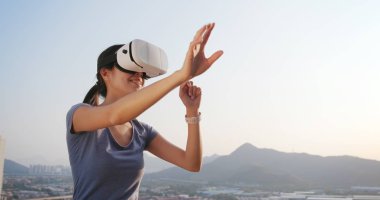 Kadın VR aygıtla günbatımı anda oynamak 
