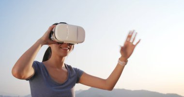 Kadın VR aygıtla günbatımı anda oynamak 