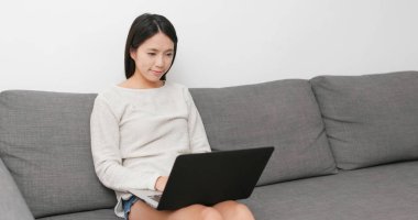 Evde dizüstü bilgisayar üzerinde çalışan kadın 