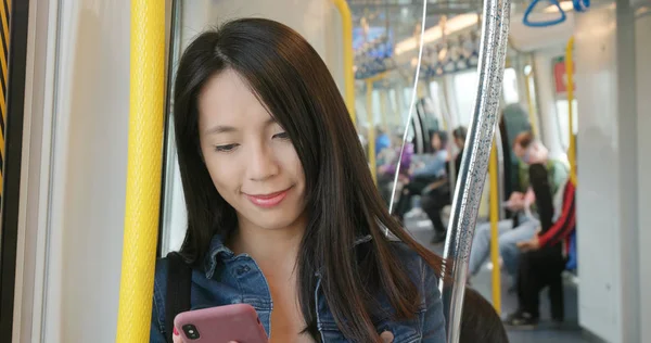 Woman using mobile phone in train