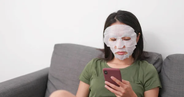 Wanita Menerapkan Masker Ski Wajah Dan Menggunakan Ponsel Rumah — Stok Foto