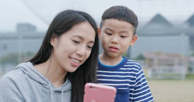 Anne ve oğlu Şehir Parkı içinde hareket eden telefon ile sohbet