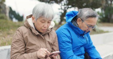 Yaşlı çift Smartphone birlikte açık Sokağı'nda kullanma 