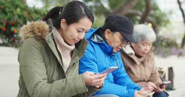 Asya sokakta akıllı telefon kullanarak aile 