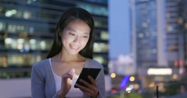 Kadın cep telefonu üzerinde akşam açık işe 