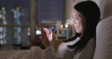 Akşamları evde cep telefonu kullanan kadın 