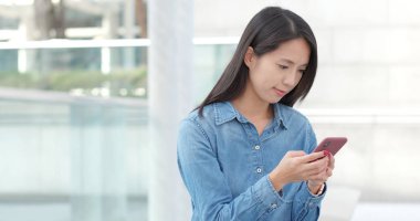 Kadın cep telefonuna bak. 