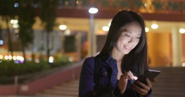 Geceleri cep telefonu kullanan bir kadın. 