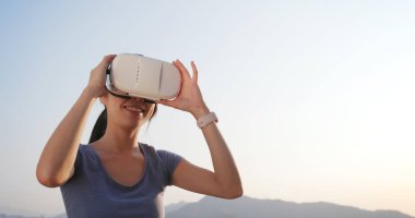 Kadın VR aygıtla günbatımı anda oynamak 