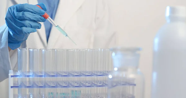 Wetenschapper Met Een Pipet Analyseert Een Gekleurde Vloeistof Uit Pakken — Stockfoto