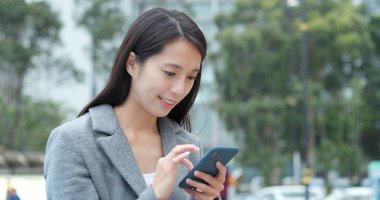 Şehirde Smartphone kullanarak iş kadını 