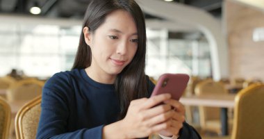 Restoranda cep telefonu kullanan kadın 