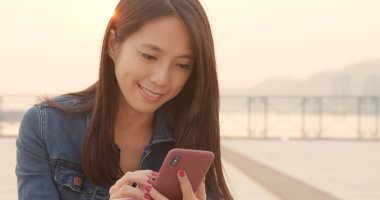 Güneş patlaması ile cep telefonu kullanan genç kadın