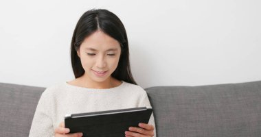 Evde tablet bilgisayarda çalışan kadın 