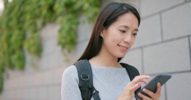 Şehirde cep telefonu kullanan genç bir kadın. 