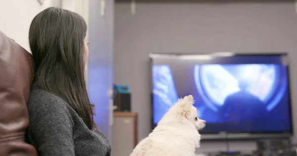 Woman watching tv with her dog