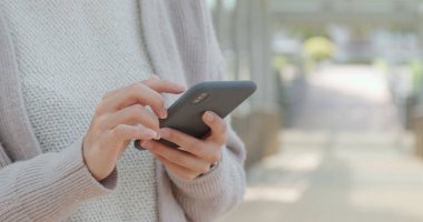 Elinde cep telefonu kullanan kadın