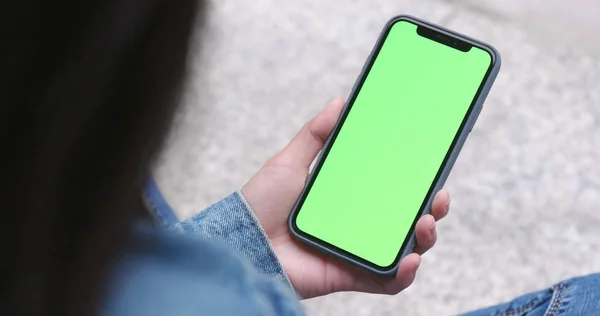 Woman using cellphone with green screen