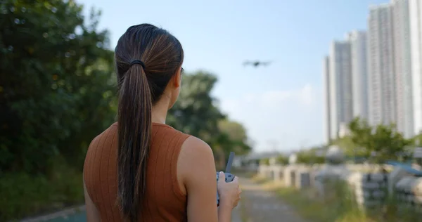 Kvinna lek med flygande drönare på utomhus — Stockfoto