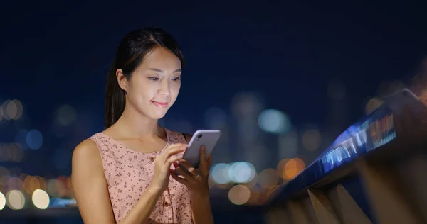 Kvinnors användning av mobiltelefon på natten och stående utomhus — Stockfoto