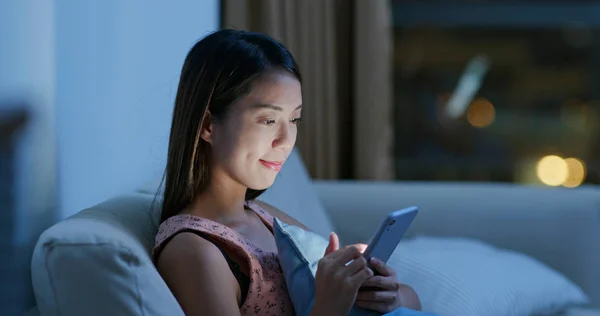 Woman look at cellphone at home in the evening