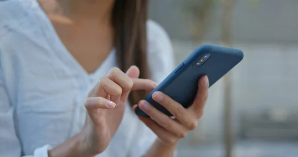 Kvinna titta på mobiltelefon på gatan — Stockfoto