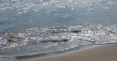 Akşamları kumlu sahilde su dalgası