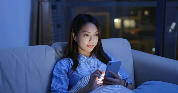 Mujer uso del teléfono móvil en línea por la noche —  Fotos de Stock