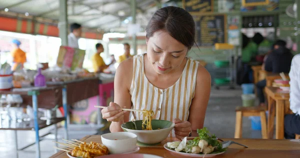 Nő eszik csónak tészta szabadtéri utcai eladó Thaiföldön — Stock Fotó