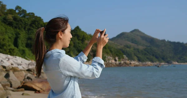Kobieta zrobić zdjęcie na telefon komórkowy z morza — Zdjęcie stockowe