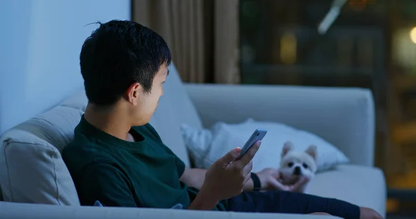 Homem uso de telefone celular com seu cão pomerano — Fotografia de Stock