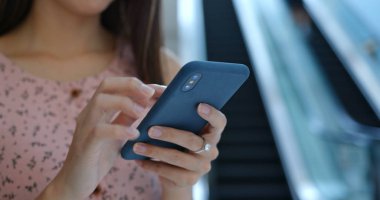 Woman use of cellphone inside shopping mall